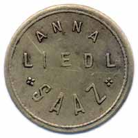 Známka Anny Liedl, mosaz, průměr 25,5 mm, vyrobená na přelomu dvacátých a třicátých let 20. století v žatecké ražebně Rudolf Lässig