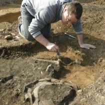 Terénní technik žateckého muzea Mgr. M. Černý odkrývá kosterní pozůstatky v hrobě u Chudeřína. Foto: P. Holodňák