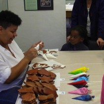 Juliána Twumová z Loun ukazuje dětem, jak se zdobí perníčky cukrovou polevou. 
